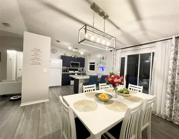 a kitchen with a refrigerator a table and chairs in it