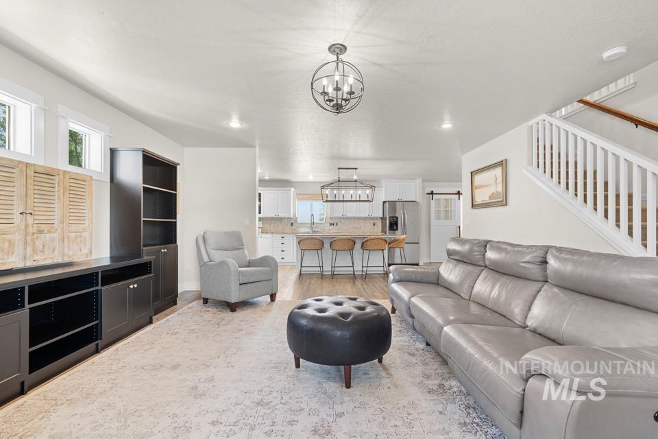 23800 Breyer Road Caldwell, ID 83607 - Photo 6 of 50 Open-concept living space featuring wood-finish flooring and a vaulted ceiling with recessed lighting