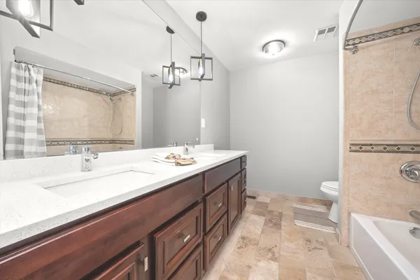 a spacious bathroom with a tub sink and mirror