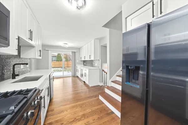 a large kitchen with kitchen island a large counter top space a sink stainless steel appliances and cabinets