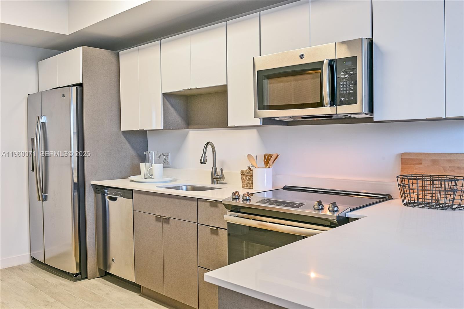 321 Northeast 26th Street, Unit 805 Miami, FL 33137 - Photo 16 of 23 a kitchen with stainless steel appliances a sink a stove a microwave and cabinets