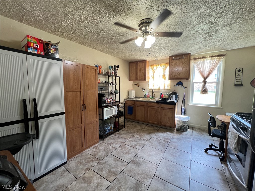 101 Shields Road Youngstown, OH 44512 - Photo 5 of 10 GENEROUS KITCHEN WITH NEWER CABINETS, CERAMIC TILE FLOORING AND CEILING FAN WITH OVERHEAD LIGHTING.