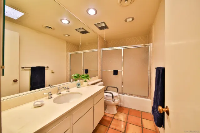 a bathroom with a sink and mirror with toilet