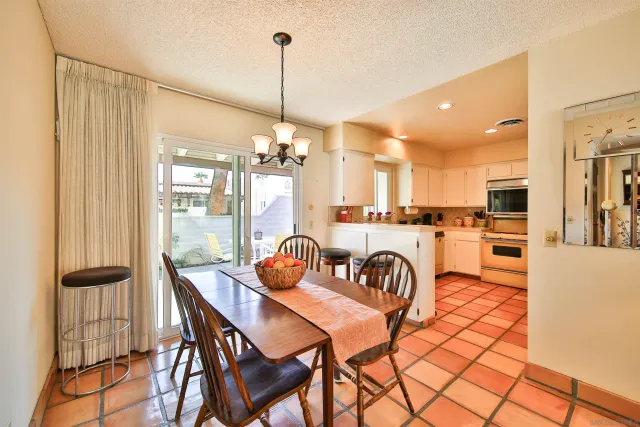 a view of a dining room and livingroom with furniture wooden floor a chandelier