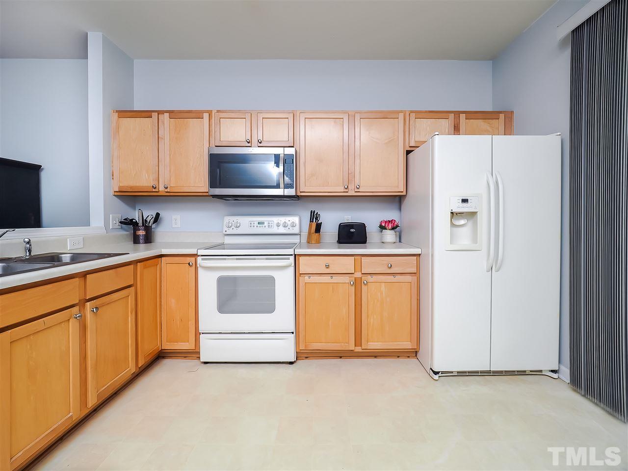 1715 Grace Brook Road Raleigh, NC 27609 - Photo 12 of 20 a kitchen with white cabinets and white appliances