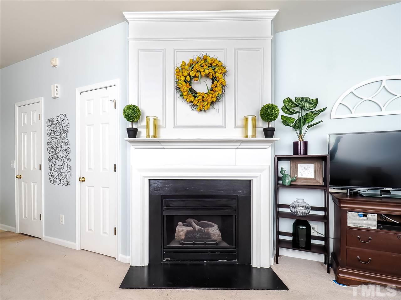 1715 Grace Brook Road Raleigh, NC 27609 - Photo 8 of 20 a living room with furniture a fireplace and a flat screen tv