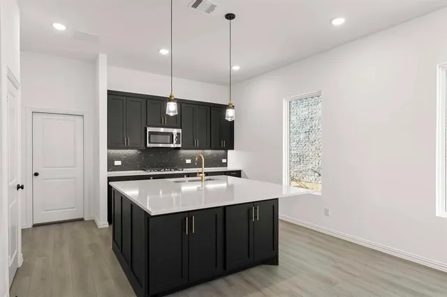 a kitchen with stainless steel appliances granite countertop a sink a oven a refrigerator and a stove