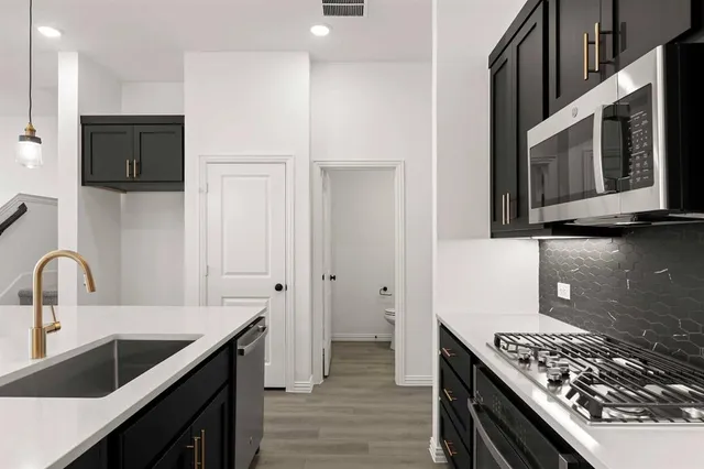 a kitchen with stainless steel appliances granite countertop a sink stove and cabinets