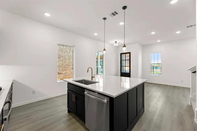 a kitchen with a sink chandelier and wooden floor