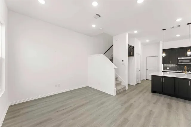 a view of a kitchen with wooden floor and electronic appliances