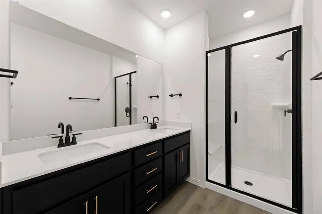 a bathroom with a double vanity sink a mirror a shower and vanity