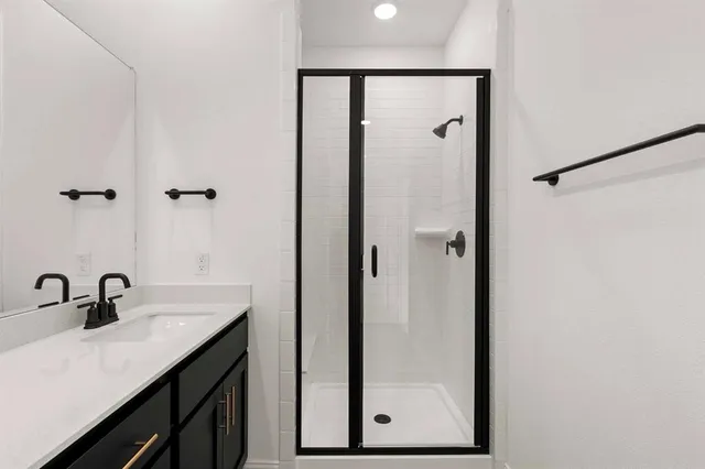 a bathroom with a shower sink and mirror
