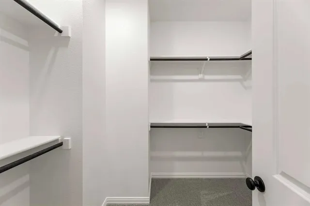 a view of walk in closet with empty racks