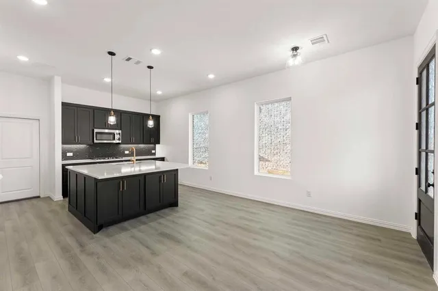 a large kitchen with a large counter top and stainless steel appliances