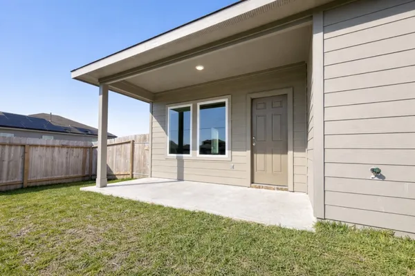 a view of backyard with tub and wooden fence