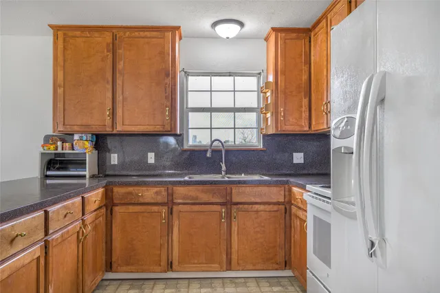 a kitchen with stainless steel appliances granite countertop a refrigerator and a sink