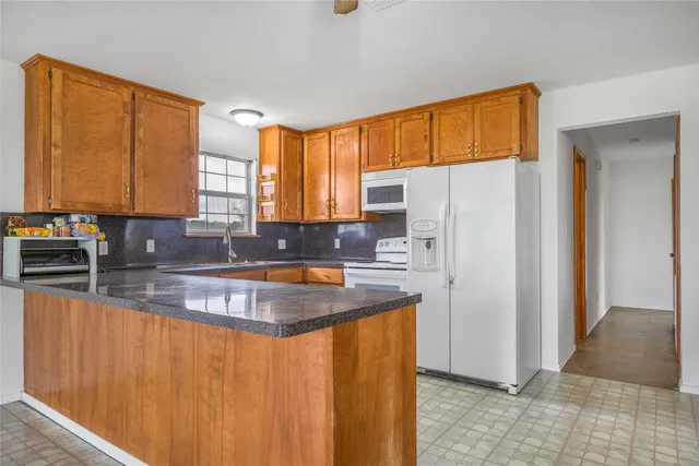a kitchen with stainless steel appliances granite countertop a refrigerator a sink a stove and island