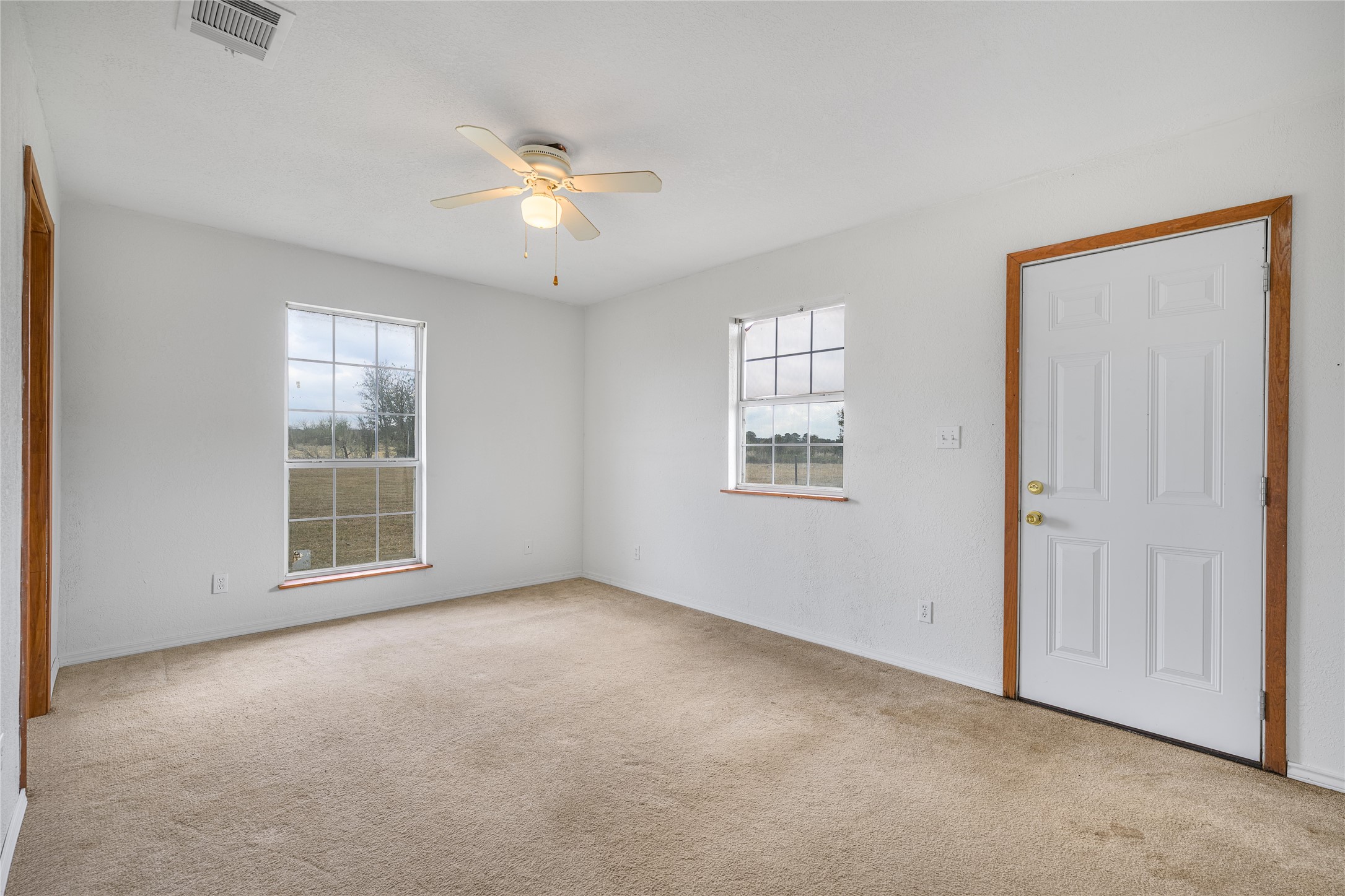 174 Easley Road Smithville, TX 78957 - Photo 22 of 28 an empty room with windows and fan