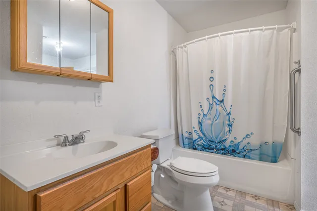 a bathroom with a sink a toilet and shower curtain