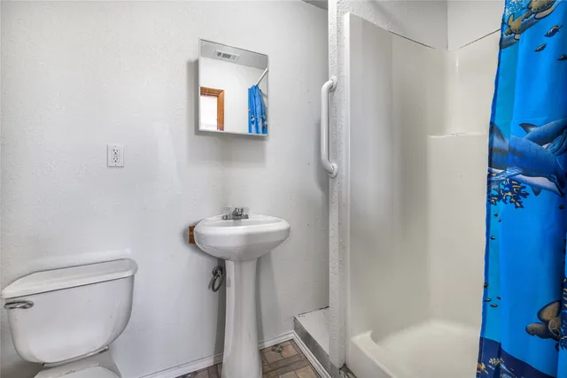 a bathroom with a sink toilet and shower