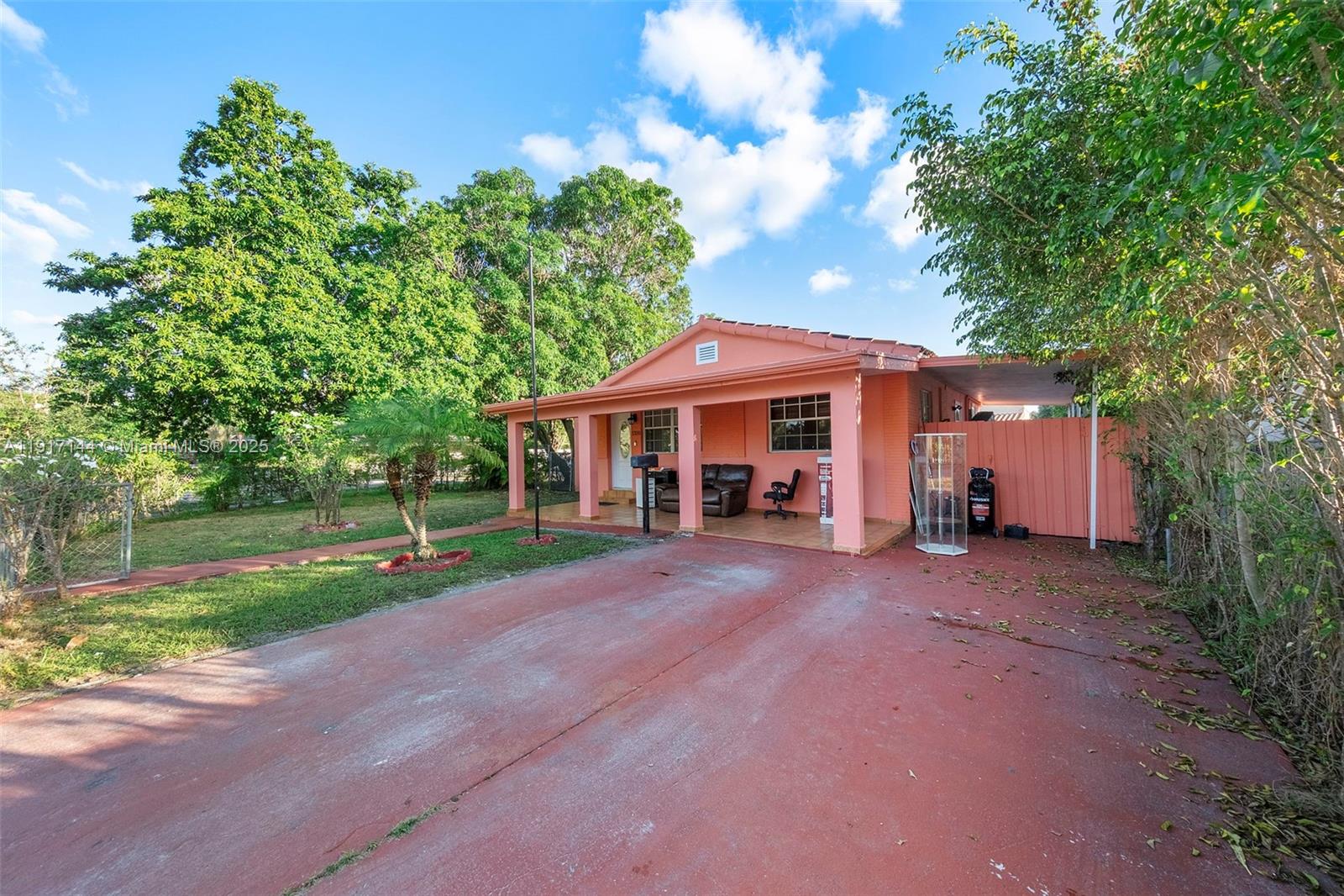 a view of a house with a yard and large tree