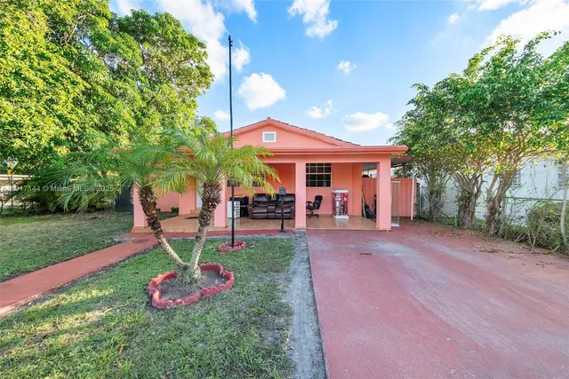 a view of a backyard with table and chairs under an umbrella