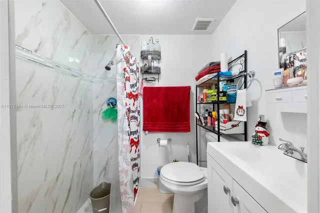 a bathroom with a sink a toilet and shower curtain