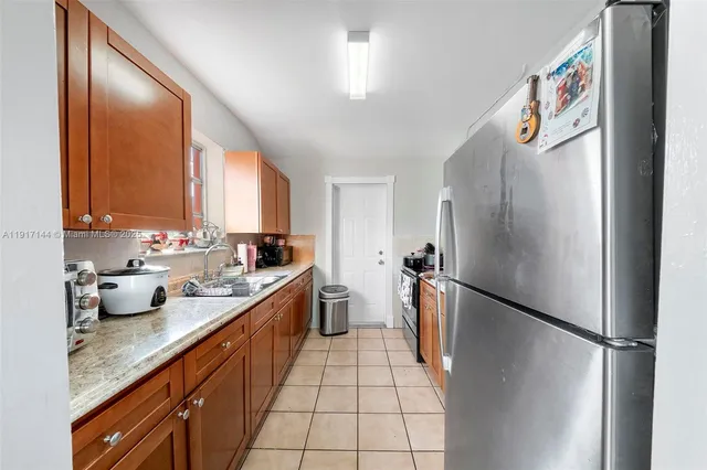a kitchen with stainless steel appliances granite countertop a refrigerator and a sink