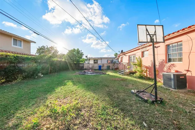 a view of an house with backyard and a tree