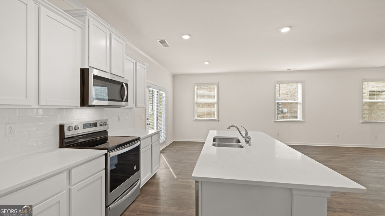 265 Sound Circle Stockbridge, GA 30281 - Photo 4 of 30 a kitchen with a sink a microwave and cabinets