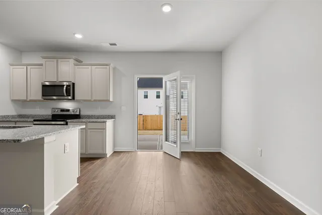 a kitchen with a refrigerator a stove top oven a sink and dishwasher with wooden floor