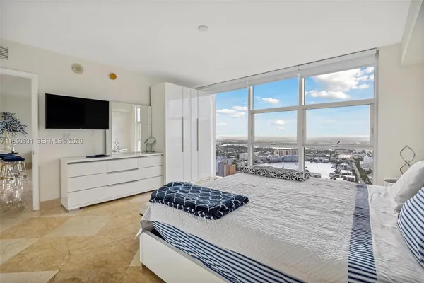 a bedroom with a bed and flat screen tv