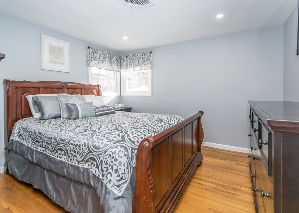 89 Pine Hill Circle Waltham, MA 02451 - Photo 13 of 32 a bedroom with a bed and wooden floor