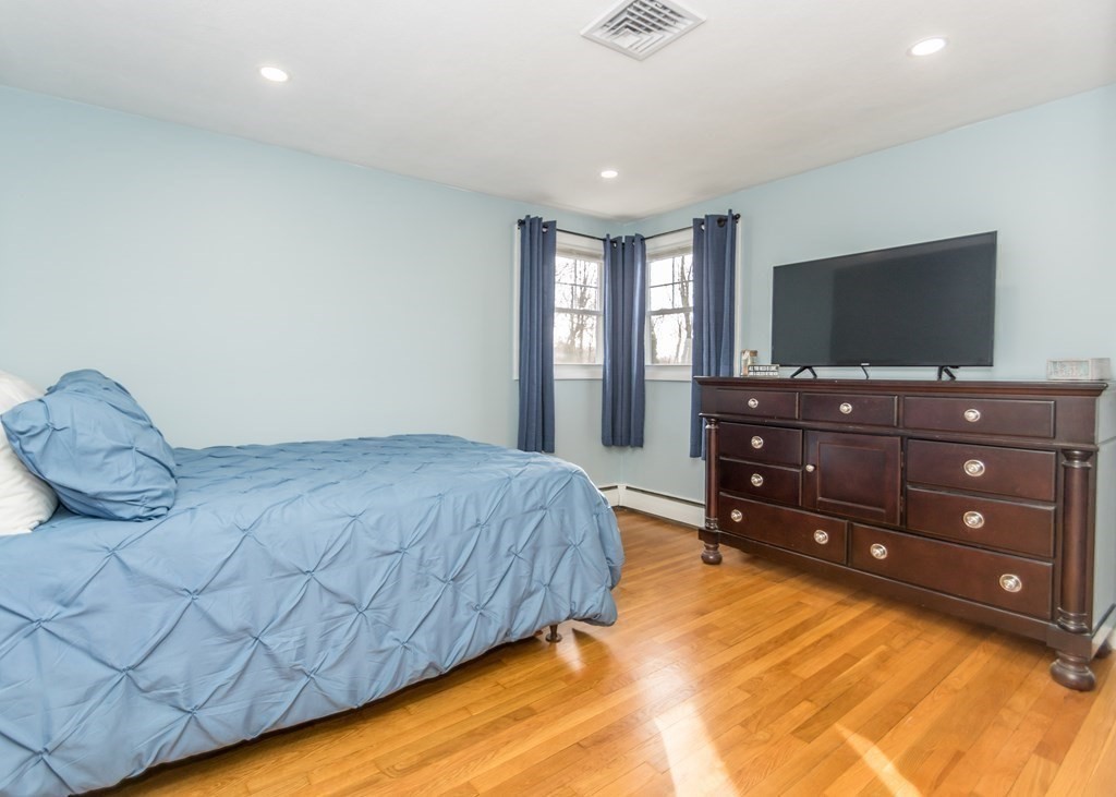 89 Pine Hill Circle Waltham, MA 02451 - Photo 16 of 32 a bedroom with a bed and a flat screen tv