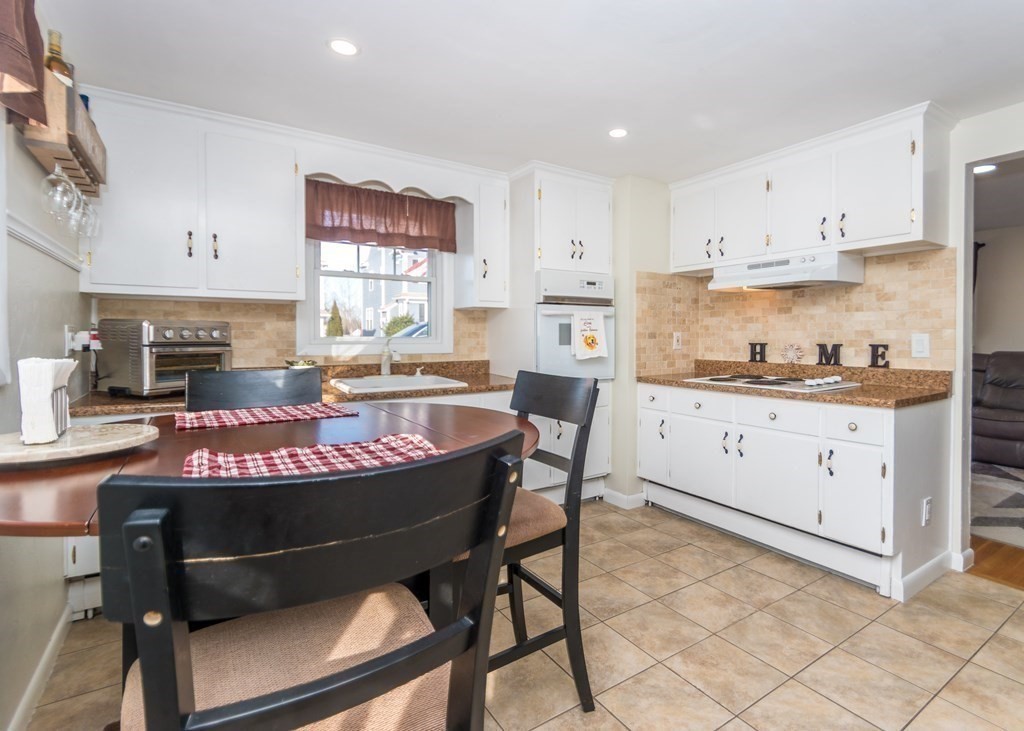 89 Pine Hill Circle Waltham, MA 02451 - Photo 5 of 32 a kitchen with stainless steel appliances granite countertop a stove a sink dishwasher and white cabinets with wooden floor