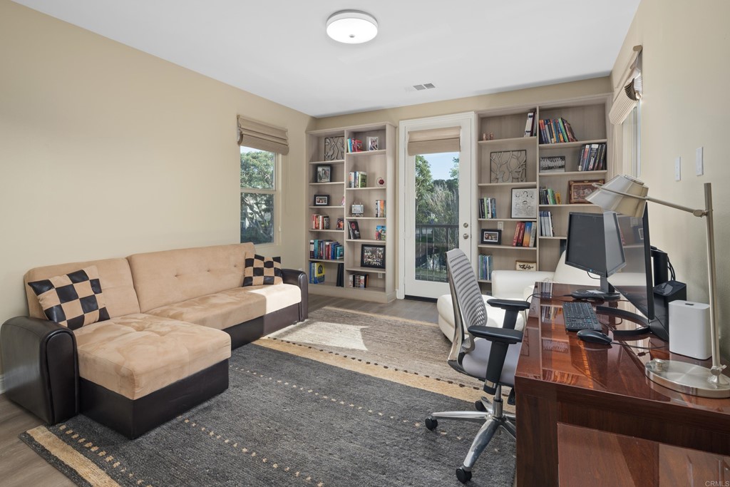 698 Normandy Road Encinitas, CA 92024 - Photo 21 of 35 a living room with furniture a bookshelf and a large window