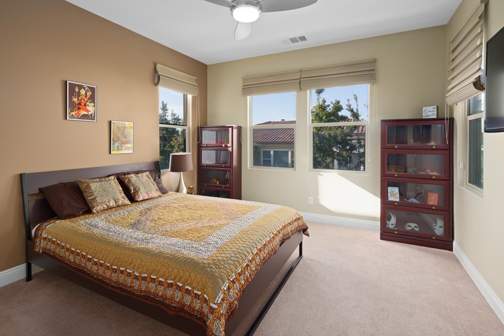 698 Normandy Road Encinitas, CA 92024 - Photo 26 of 35 a spacious bedroom with a bed and glass door
