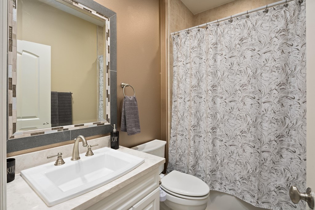 698 Normandy Road Encinitas, CA 92024 - Photo 27 of 35 a bathroom with a sink a toilet and shower curtain