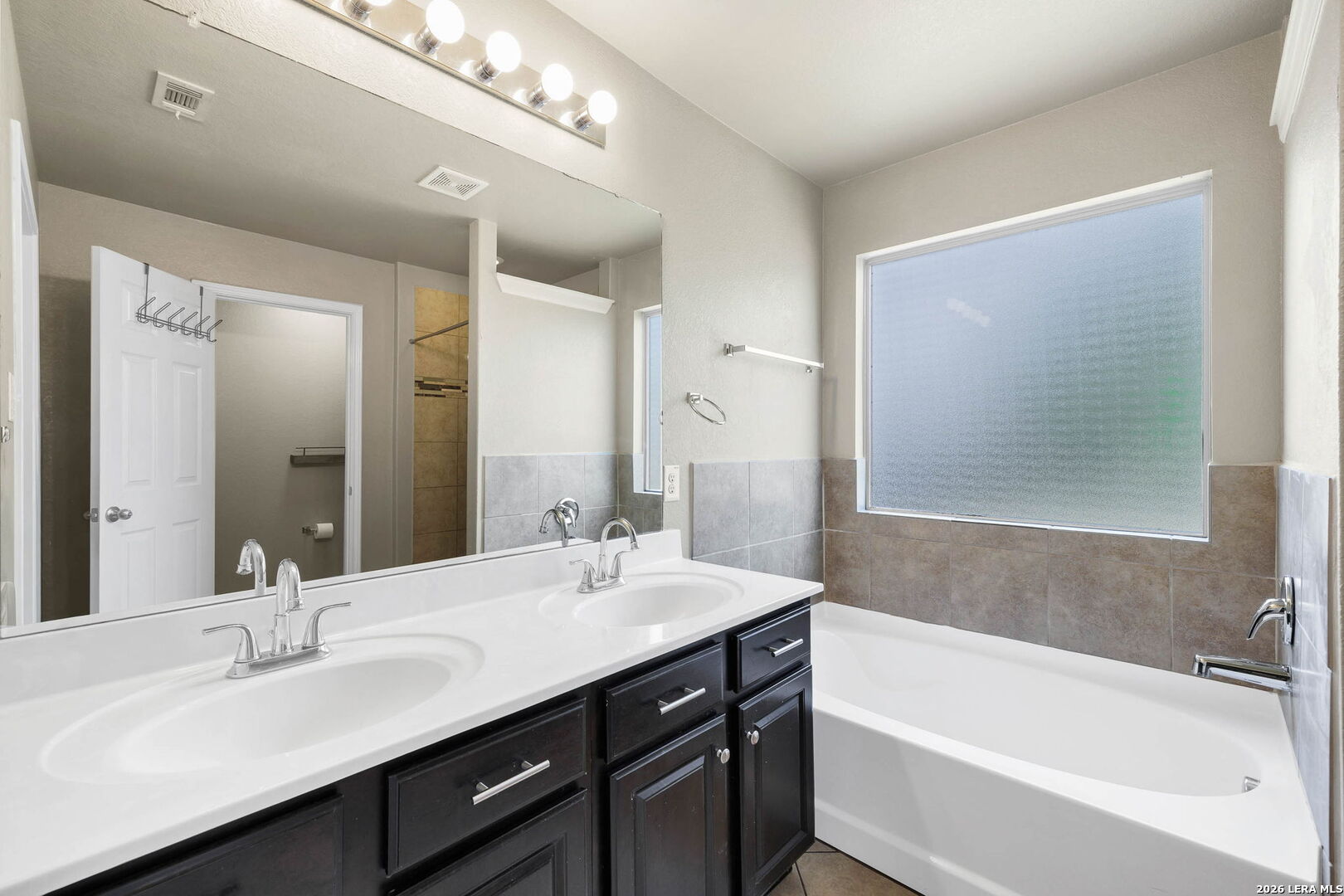 4015 Shervin Way Converse, TX 78109 - Photo 28 of 43 a bathroom with a bathtub double vanity sink and mirror