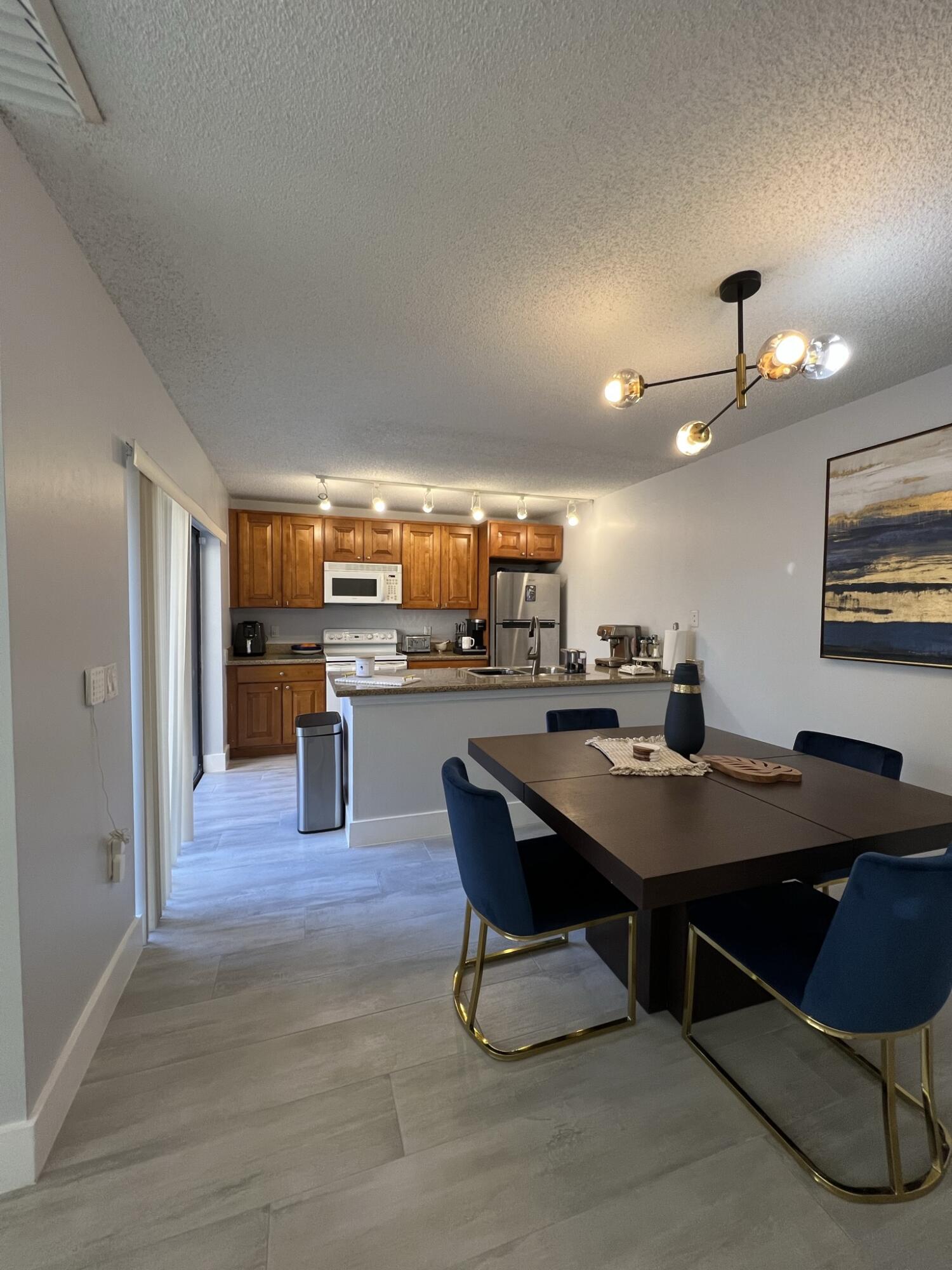 802 Blue Ridge Circle West Palm Beach, FL 33409 - Photo 17 of 37 a room with stainless steel appliances kitchen island a table and chairs in it