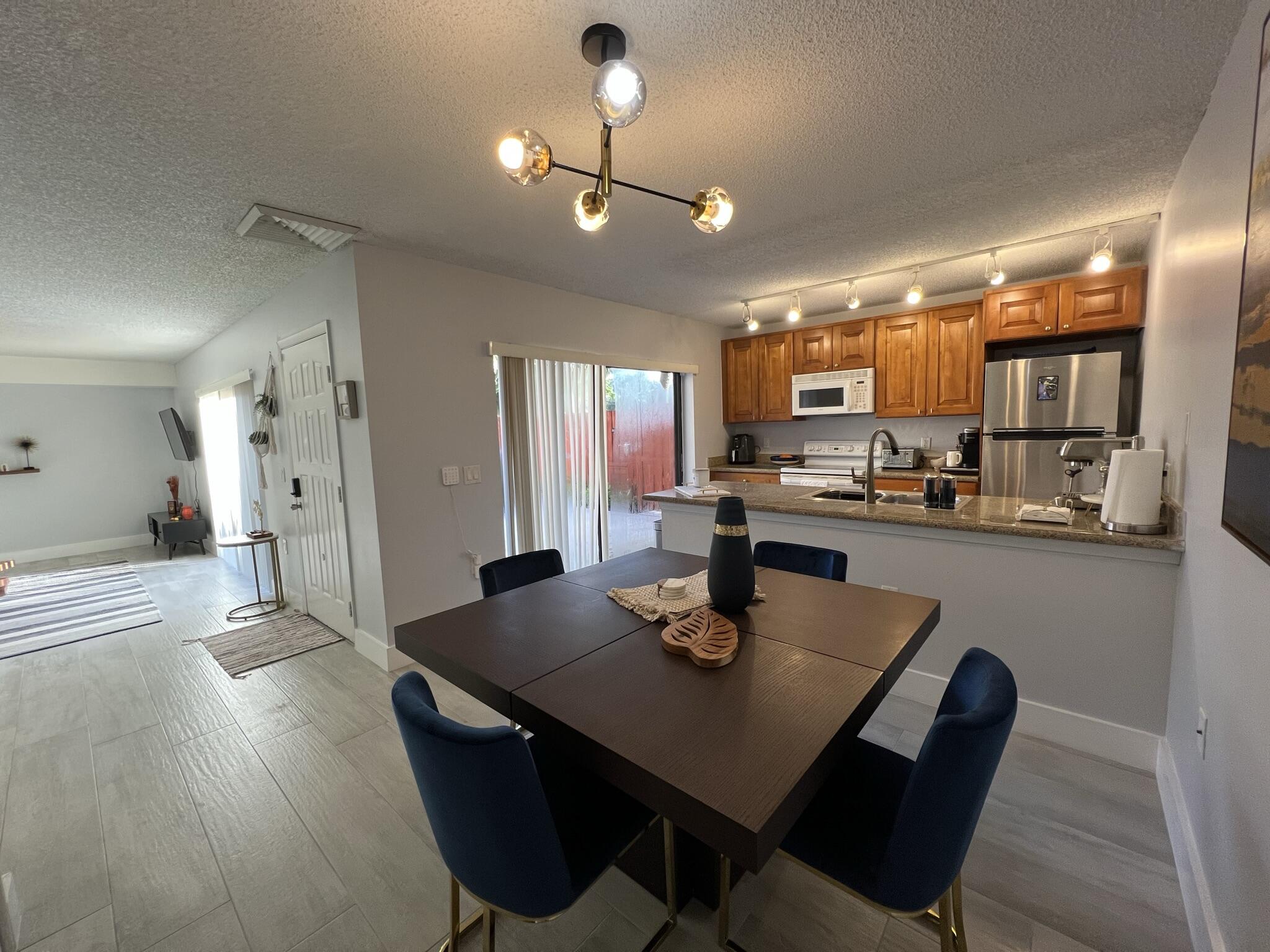 802 Blue Ridge Circle West Palm Beach, FL 33409 - Photo 18 of 37 a kitchen with a dining table chairs and refrigerator