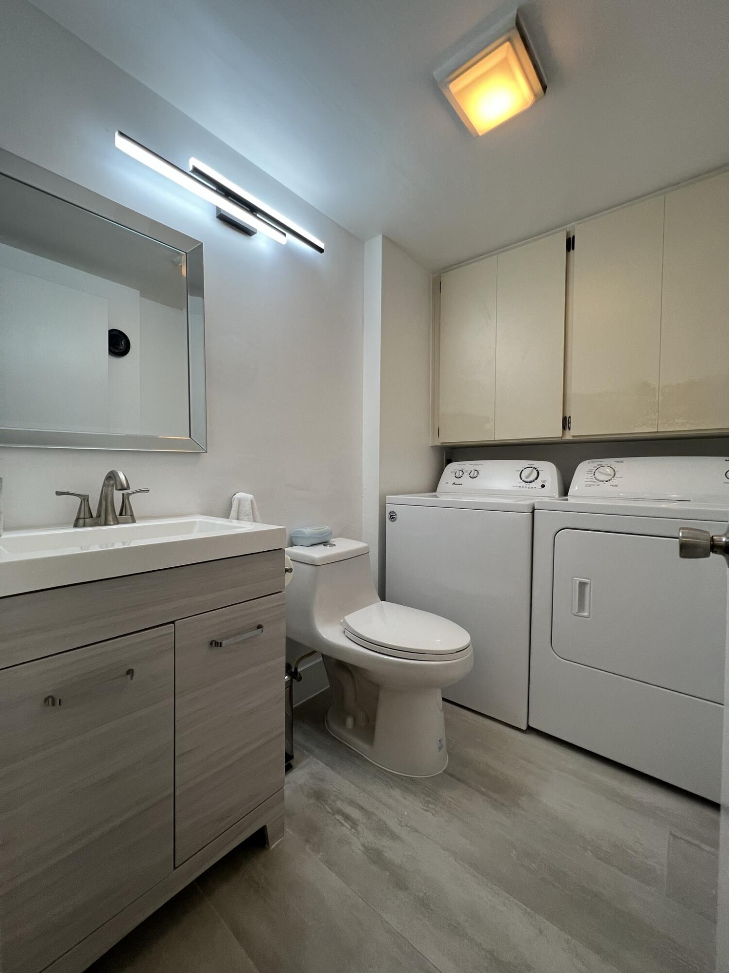 802 Blue Ridge Circle West Palm Beach, FL 33409 - Photo 19 of 37 a bathroom with a toilet sink and mirror