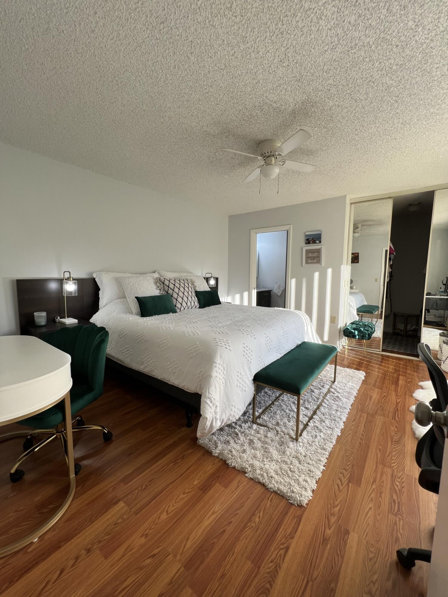 802 Blue Ridge Circle West Palm Beach, FL 33409 - Photo 20 of 37 a bedroom with a bed a couch and a dresser with wooden floor