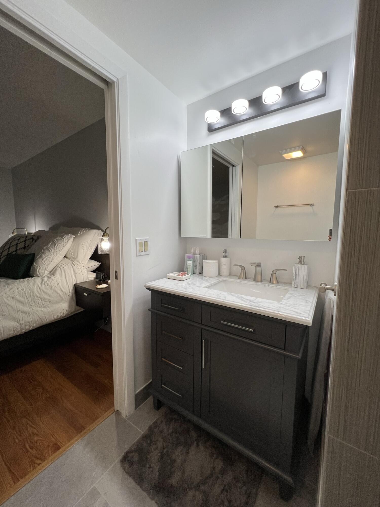 802 Blue Ridge Circle West Palm Beach, FL 33409 - Photo 29 of 37 a en suite bathroom with a double vanity sink and a mirror