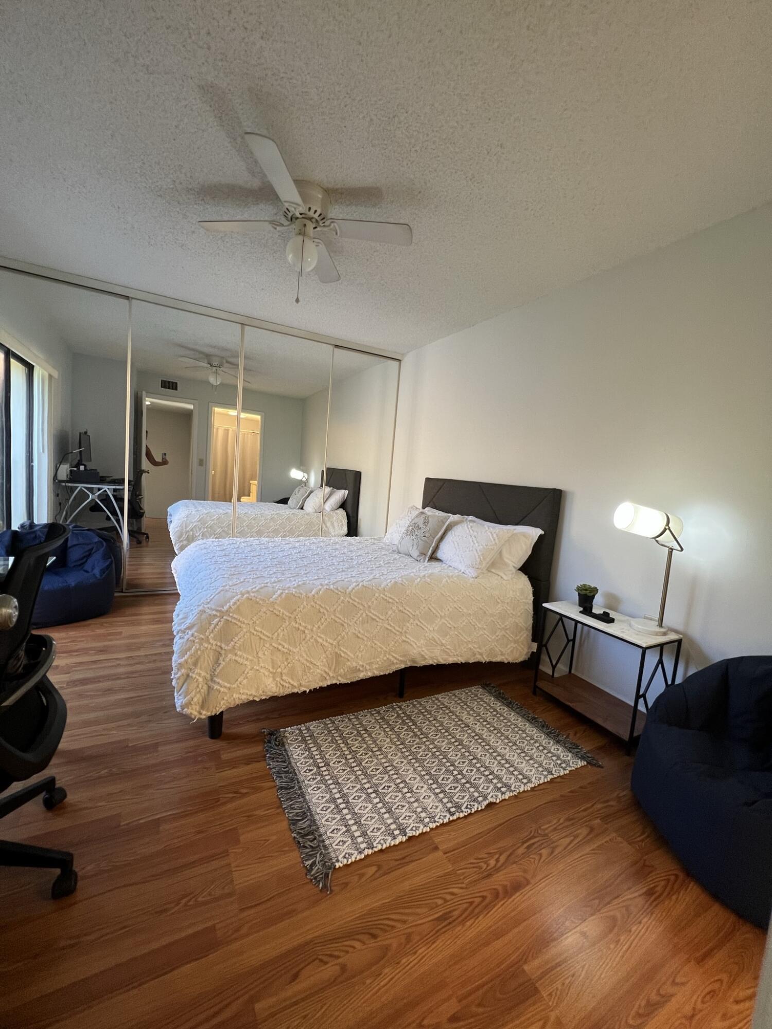 802 Blue Ridge Circle West Palm Beach, FL 33409 - Photo 33 of 37 a bedroom with double bed windows and a wooden floor