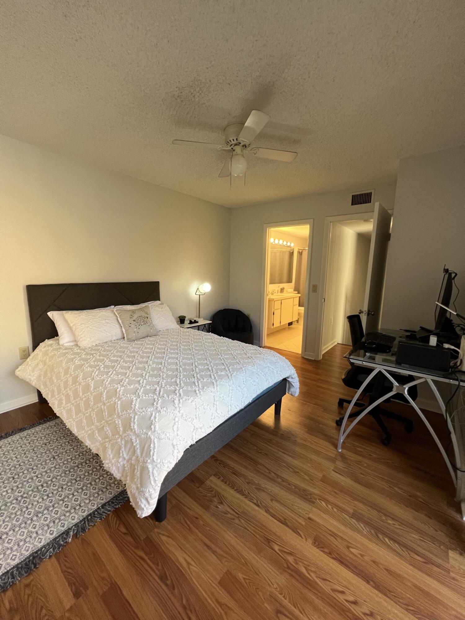 802 Blue Ridge Circle West Palm Beach, FL 33409 - Photo 34 of 37 a bedroom with a bed and wooden floor