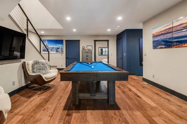 a living room with table chairs and a wooden floor