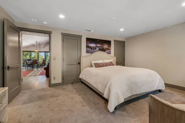 a large bedroom with a bed and glass door