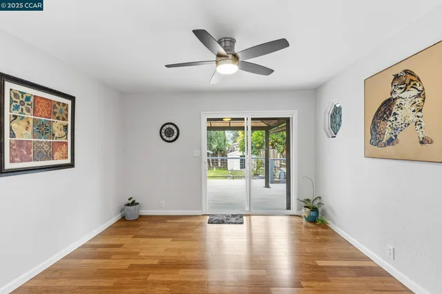 a view of an empty room with window and wooden floor