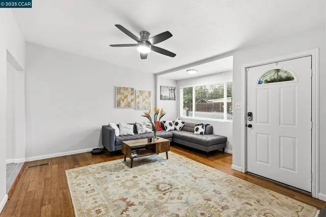 a living room with furniture and a wooden floor